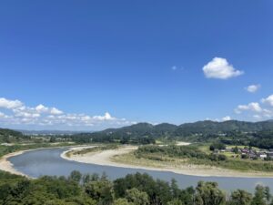 青空と山々に囲まれた信濃川の雄大な風景