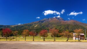 紅葉した木々と青空に映える秋の山岳風景
