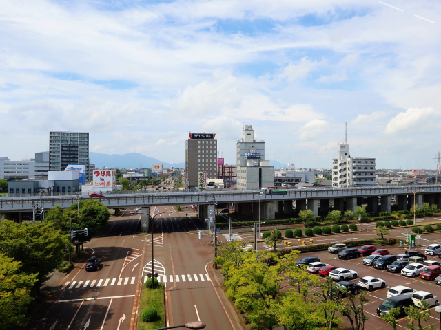 青空の下に広がる新潟市の道路と市街地