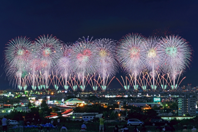 夜空を彩る大規模な花火大会と市街地の夜景